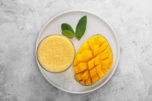 Lassi is a popular traditional yogurt based cold drink with mango in India, top vew Lassi is a popular traditional cold drink with mango in India. Lassi consists of yogurt, water, spices and sometimes fruit and ice, top view mango smoothie stock pictures, royalty-free photos & images