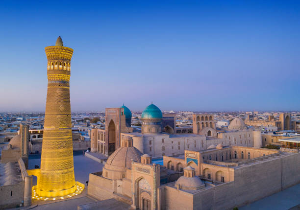 Last daylight at the city of Bukhara, historic silk road, Uzbekistan Panoramic view of the center of Bukhara around the Kalyan minaret (nearly 46 m hight and build in the early 12th century!). In the background of the minaret the Mir-i Arab Madressa and the Kaylan mosque (both 16th century) are visible. The center of Bukhara (also calloed Buchara or Buxoro) is listed as UNESCO World Heritage Site. Bukhara was one of the most important oasis and place of caravanserais at the Great Silk Road. bukhara stock pictures, royalty-free photos & images