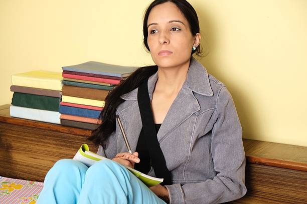 Stressed indian student doing exam preparations in her room