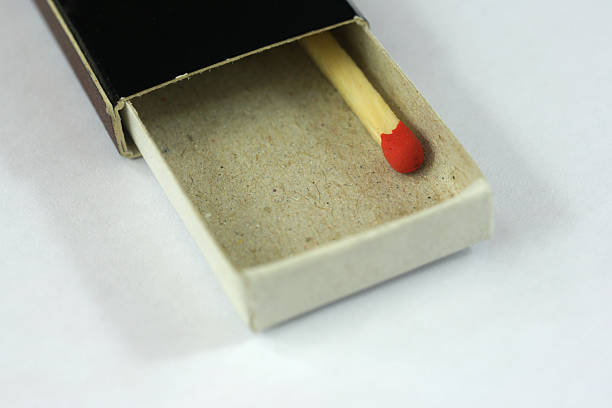 Last red matchstick in a black box stock photo