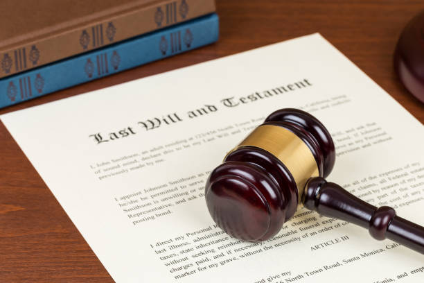 Last will and testament with wooden judge gavel; document is mock-up not real stock photo
