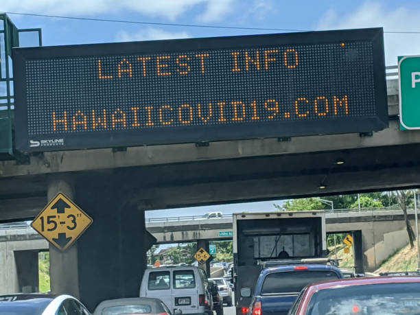 Latest Info HawaiiCovid19.com sign hanging over busy H-1 Highway stock photo