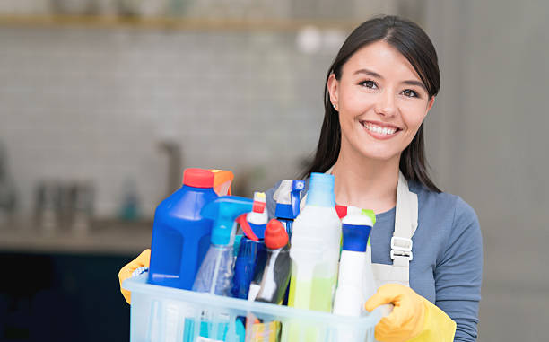 Latin American cleaning woman Portrait of a Latin American cleaning woman at home holding cleansing products and looking at the camera smiling maid stock pictures, royalty-free photos & images