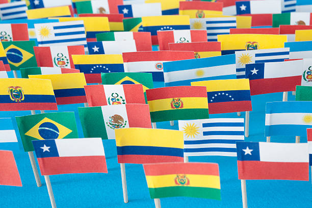 Latin American flags Lots of small handmade flags of latin american countries over blue background latin america stock pictures, royalty-free photos & images