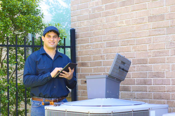 Latin descent young man, blue collar air conditioner repairman at work. stock photo