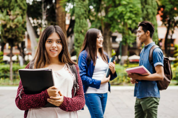 Latin female student, Hispanic girl in Mexico and group of mexican students at Background in Mexico stock photo