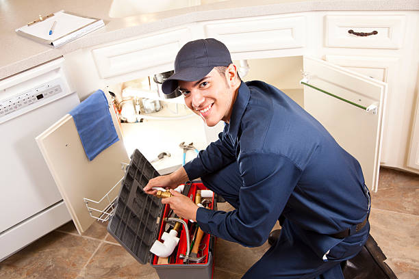 Latin Plumber, repairman working under sink, home kitchen. Service industry. stock photo