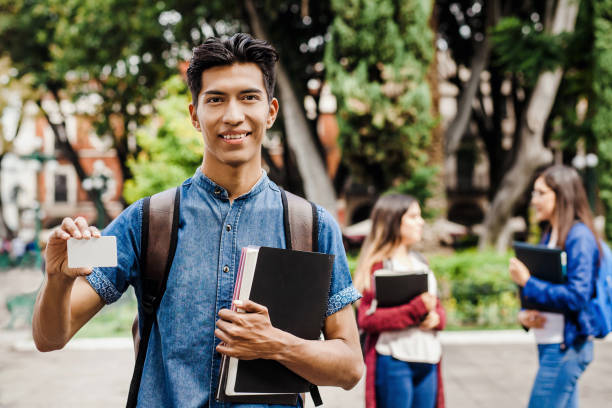 Latin student, Hispanic Man in Mexico and group of mexican students at Background in Mexico stock photo
