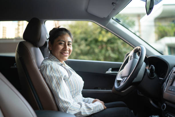 Latin woman sitting in driver's seat, driving car Latin woman sitting in driver's seat, driving car peru woman stock pictures, royalty-free photos & images