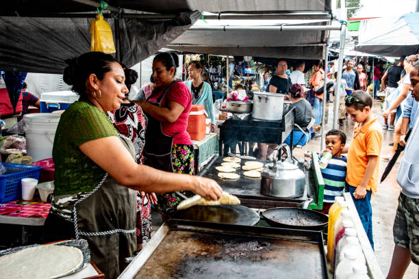 Latina woman makes tortillas in Central American market Saturday market in San Ignacio, Belize, largest in country, offers fresh food and fresh cooked food at great prices farmers market photos stock pictures, royalty-free photos & images
