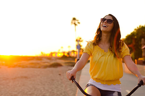 Laughing beauty on sunset bike ride stock photo