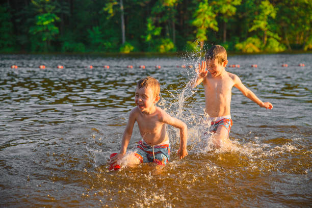 skrattande barn plaskade i sjön - bad catch bildbanksfoton och bilder