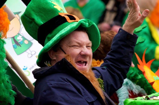 Cork, Ireland - March 17, 2012: Laughing man with an orange beard who is waving at the crowds that turned up at the Cork City St. Patrick's Day Parade. He is wearing a green leprechaun hat.