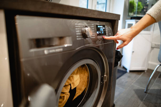 Laundry is Ready A close-up shot of an unrecognisable caucasian woman pressing a button on her washing machine. utility room photos stock pictures, royalty-free photos & images