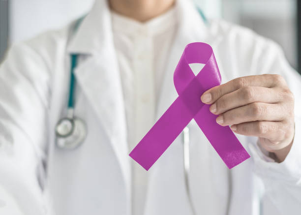 lavender purple cancer (all kinds) awareness ribbon on doctor's hand support for national cancer survivor month campaign - world cancer day imagens e fotografias de stock