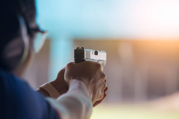 law enforcement aim pistol by two hand in academy shooting range stock photo