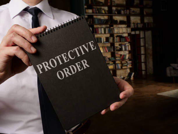 Lawyer shows info about Protective Order rules. Lawyer shows book about Protective Order rules. restraining stock pictures, royalty-free photos & images