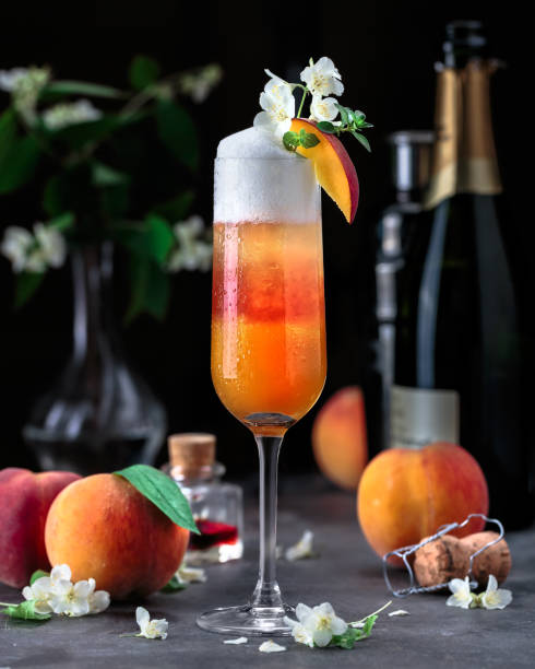 Layered bellini cocktail with peaches on dark background stock photo