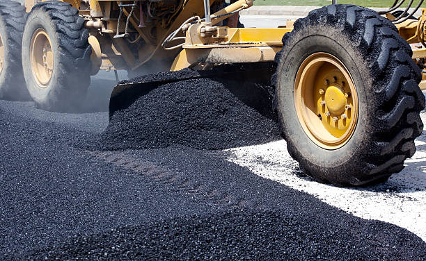Laying fresh asphalt on construction site stock photo