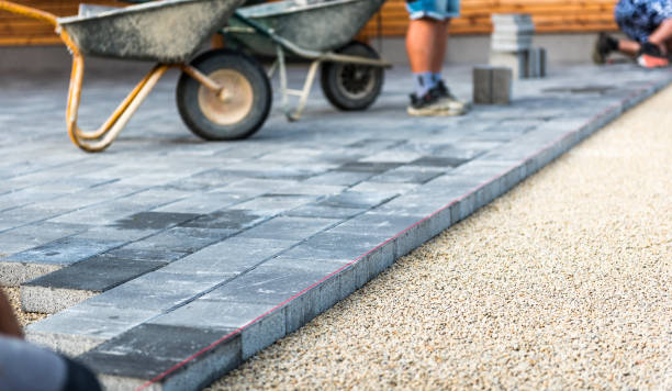 Laying gray concrete paving slabs in house courtyard driveway patio. stock photo