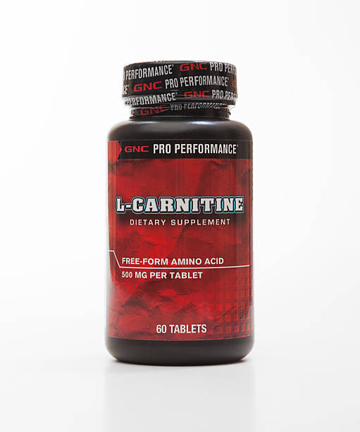 GNC L-Carnitine Istanbul, Turkey - February 12, 2013: A bottle of GNC L-carnitine dietary supplement. L-Carnitine is a popular amino acid among bodybuilders, weight trainers and serious athletes because of its role in facilitating the metabolism of long chain fatty acids.  l carnitine stock pictures, royalty-free photos & images