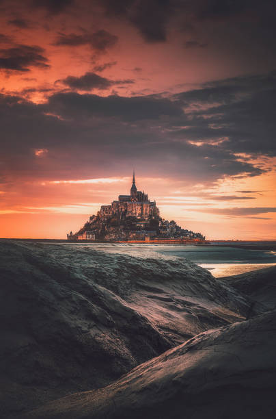 Le Mont Saint Michel at sunset in Normandy, France Beautiful view of famous  Le Mont Saint Michel. East across the tidal bay from salt marsh at a beautiful sunrise time in Normandy, Northern France manche stock pictures, royalty-free photos & images
