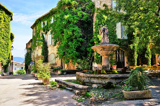 Leafy town square with fountain, Provence, France Leafy town square with fountain in a picturesque village in Provence, France village stock pictures, royalty-free photos & images