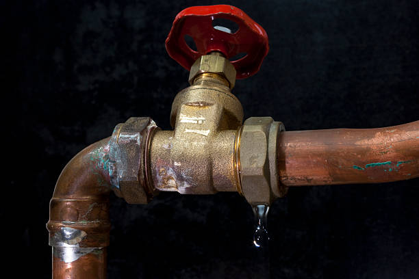 Leaking copper water pipe and stopcock valve stock photo