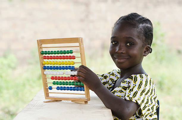 Learning Numbers with Abacus - Cute young African Girl Counting stock photo