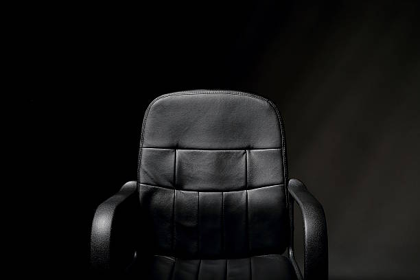 Leather Office Chair A detailed image of an empty, black, office chair chiaroscuro stock pictures, royalty-free photos & images