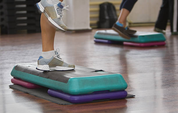 Leg view of people exercising on exercise steps in a class. stock photo