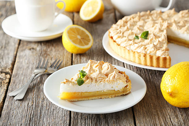 Lemon meringue pie on plate on grey wooden background stock photo