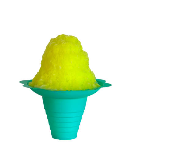 Lemon yellow or banana shaved ice, snow cone or shave ice in a blue flower shaped cone cup. stock photo