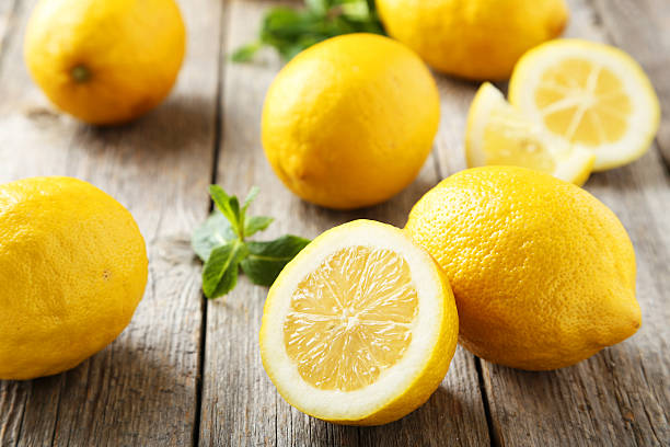 lemons on grey wooden background - citroen stockfoto's en -beelden