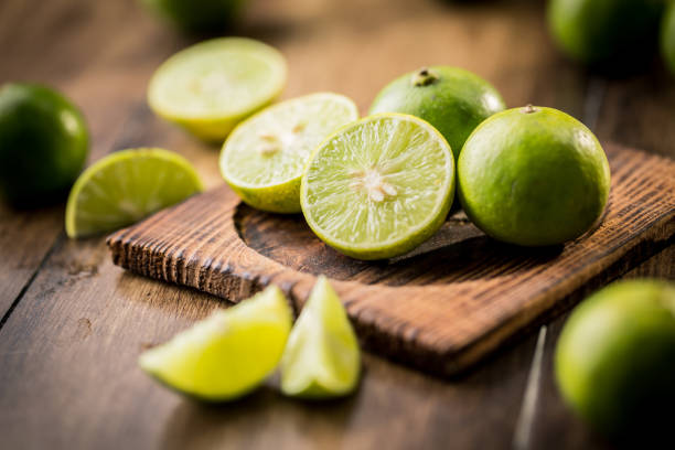 Lemons on wooden background Lemons on wooden background lime stock pictures, royalty-free photos & images