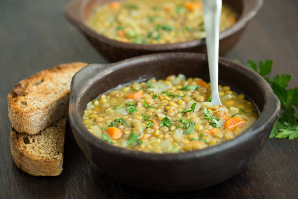 Lentil Soup Vegan lentil soup served with whole wheat bread. lentil stock pictures, royalty-free photos & images