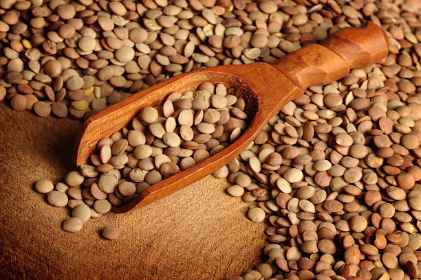 Lentils and Scoop Dried lentils with a wooden scoop lentil stock pictures, royalty-free photos & images