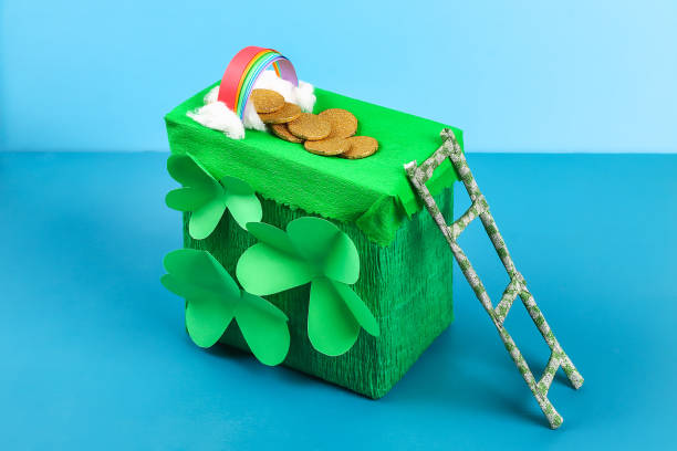 DIY leprechaun trap with gold coins, rainbow and green ladder St Patricks Day background. stock photo