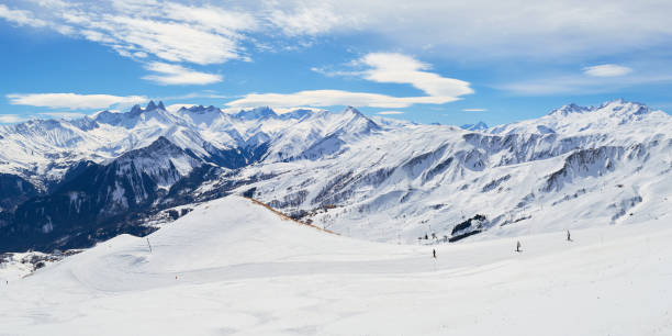 Les Sybelles ski slopes and surrounding white mountain peaks, on a sunny Winter day - panorama in the French alps. stock photo