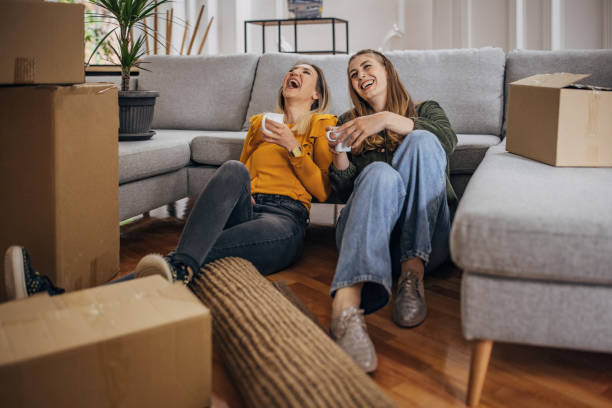 Lesbian couple relaxing in new home stock photo