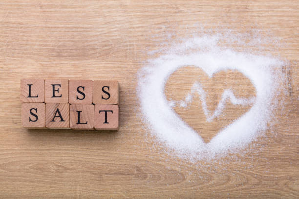 Less Salt Near Heart Shape With Heartbeat Less Salt Near Heart Shape With Heartbeat On Wooden Desk low stock pictures, royalty-free photos & images