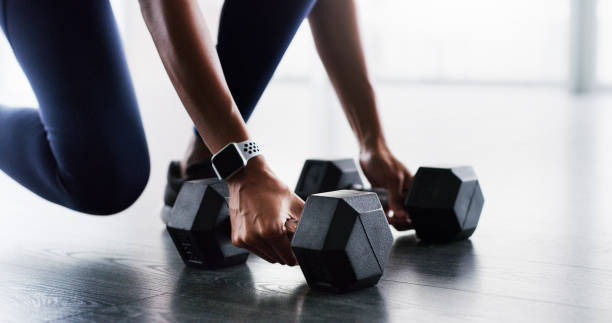 Less talking, more lifting Cropped shot of a woman working out with dumbbells in a gym less weight stock pictures, royalty-free photos & images