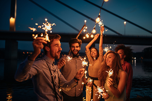 Group of friends celebrating holding sparklers