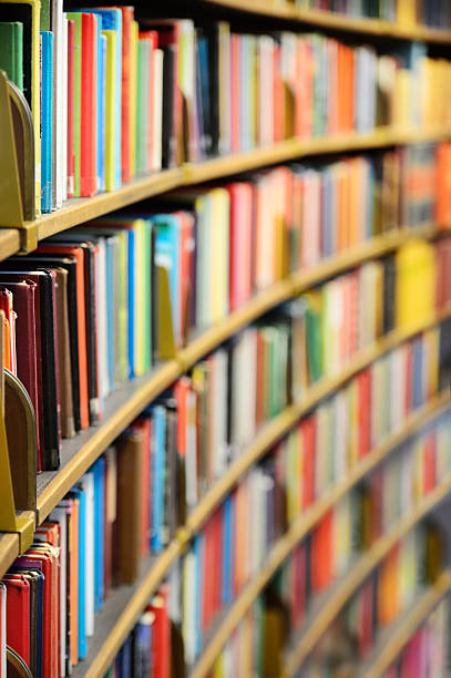 Library books on rows of shelves stock photo
