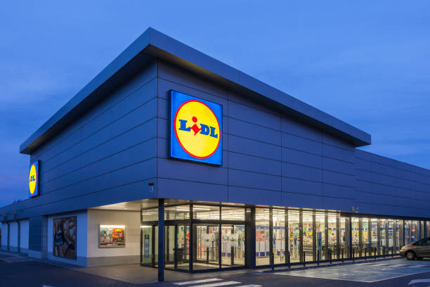 Lidl supermarket building Cartagena, Spain - May 17, 2017: New Lidl supermarket building illuminated at dusk. Lidl is german discount supermarkets chain based in Neckarsulm, Germany lidl stock pictures, royalty-free photos & images