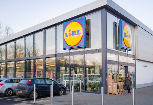 Lidl supermarket store exterior UK BUCKINGHAM, UK - December 04, 2019. Lidl supermarket store exterior, with woman shopper outside the entrance. lidl stock pictures, royalty-free photos & images