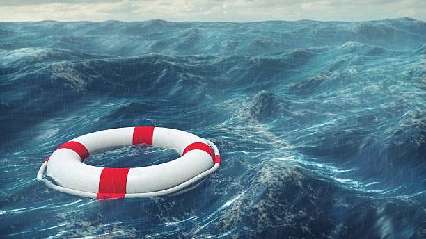Lifebuoy On The Stormy Sea Floating lifebuoy on the wavy sea. life belt stock pictures, royalty-free photos & images