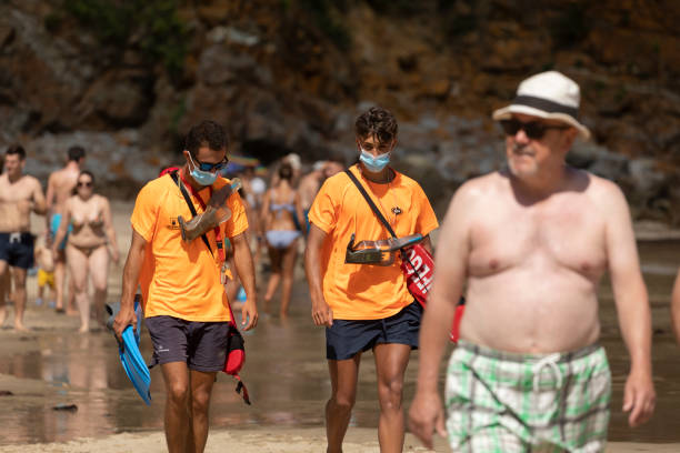 socorristas caminan por una playa de asturias, españa. - public service fotografías e imágenes de stock