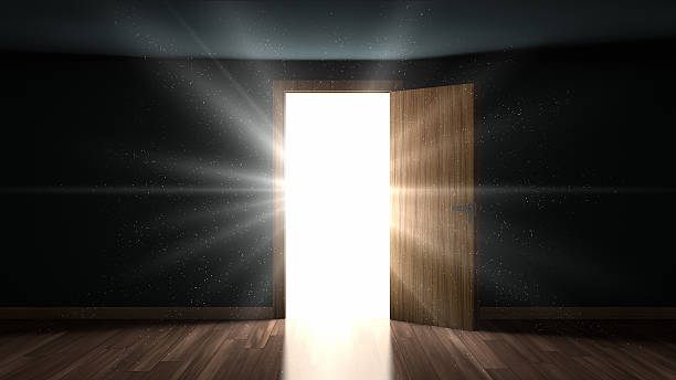 Light and particles in a room through the opening door stock photo