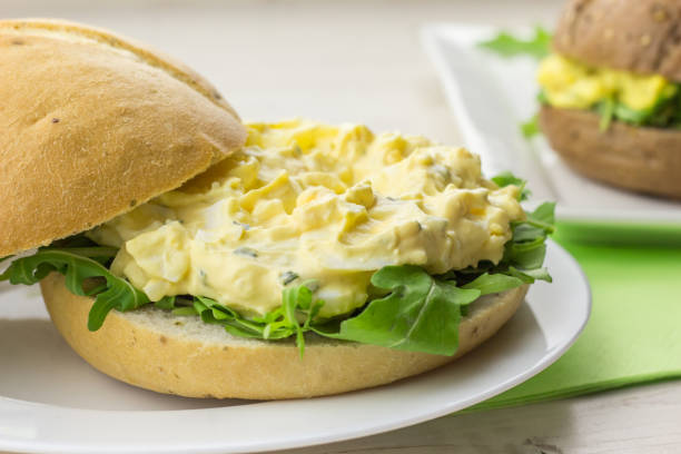 Light bread with egg and chive salad on a white plate stock photo